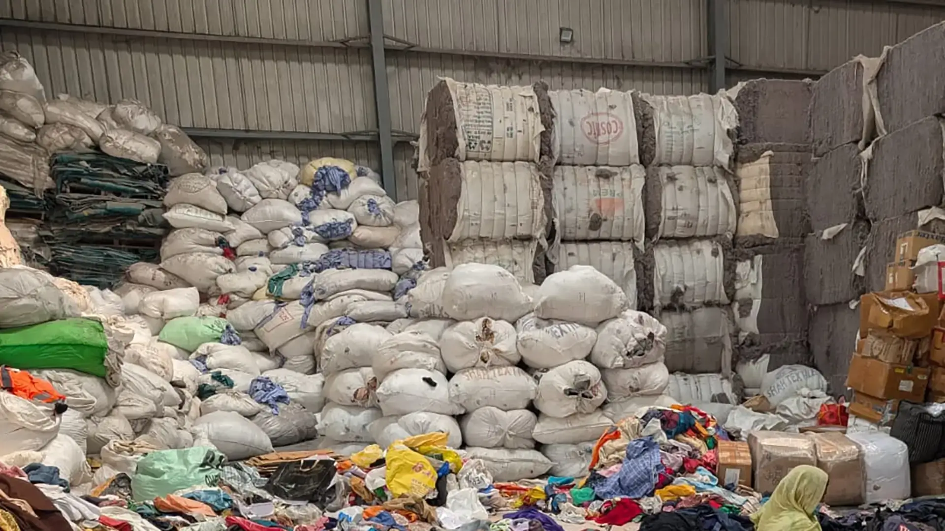 Textile waste landscape showing piles of discarded clothing and fabrics